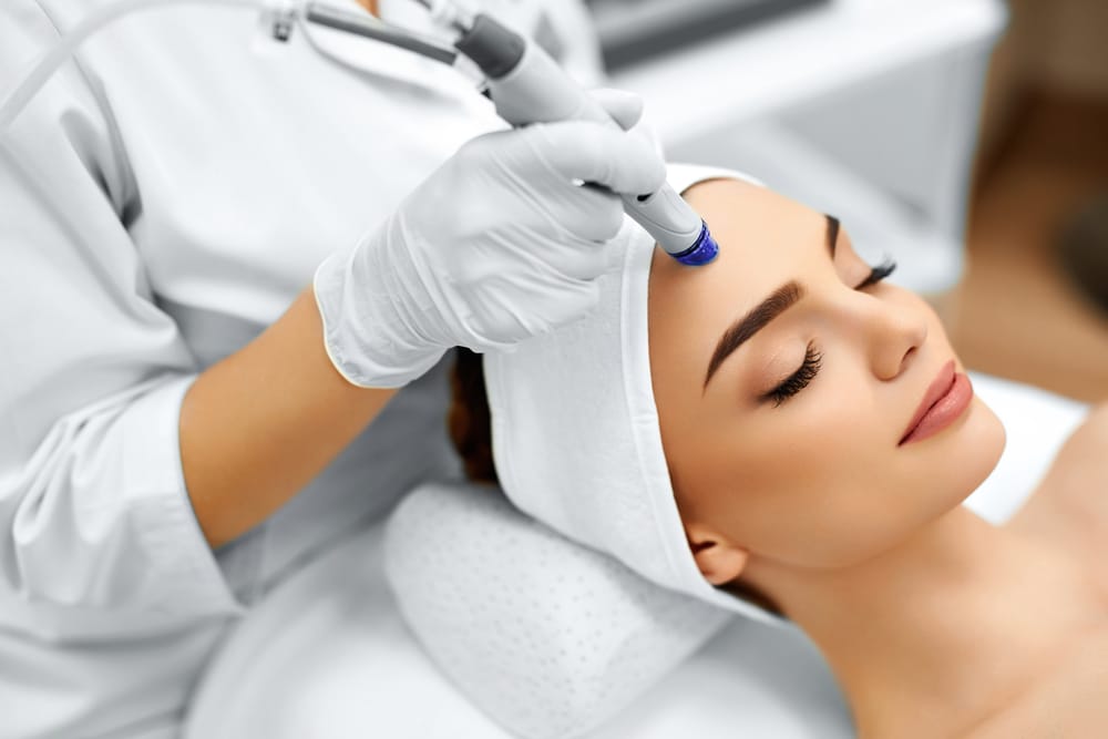 Targeted Peptide Skin Therapy to Support Cellular Renewal and Facial Rejuvenation – Peptide Treatment Provider Applying Controlled Peptide Treatment to the Forehead Using Advanced Facial Therapy Device – Peptide Treatment